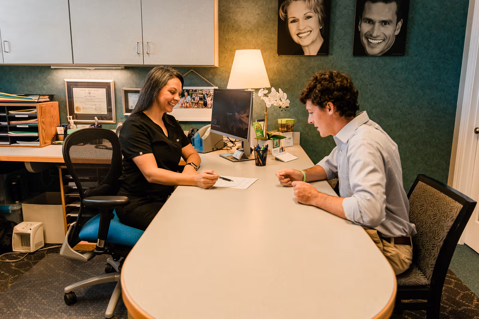 A client checking in at the front desk of Masterpiece Dentistry.