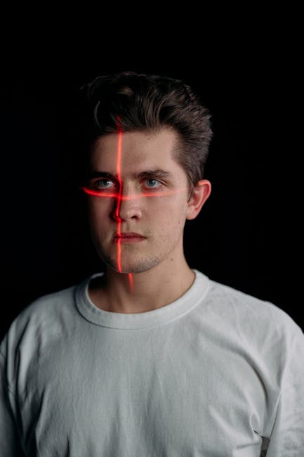 Studio portrait of a man with laser facial recognition technology on black background.