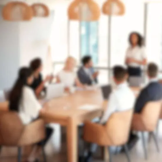 A blurred image of a team sitting around a conference table. One person is standing, possibly presenting, while others are sitting and appear to be listening attentively. The room is well-lit with large windows and modern decor.