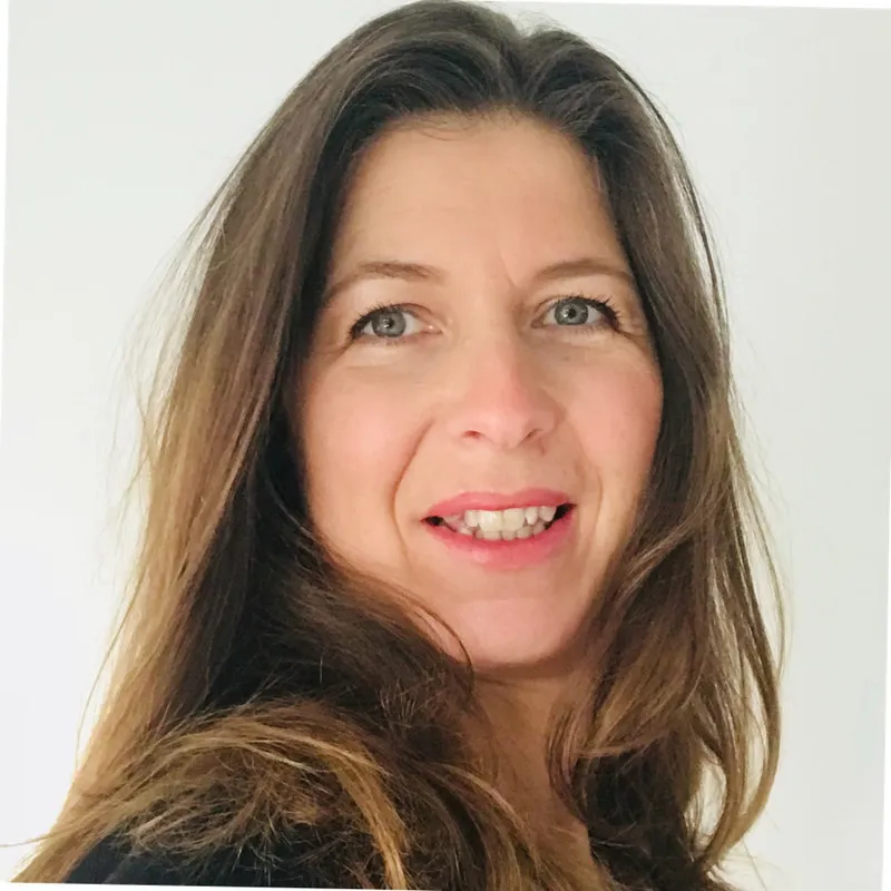 Caroline Taylor smiles in a professional headshot, her hair is down. 