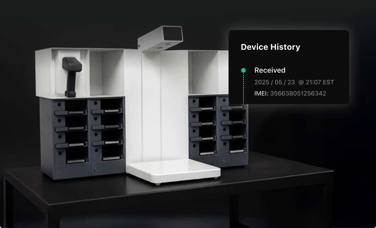 Apkudo receiving station with phone storage on either side, a scanner holder, and a large scanner connecting the storage.