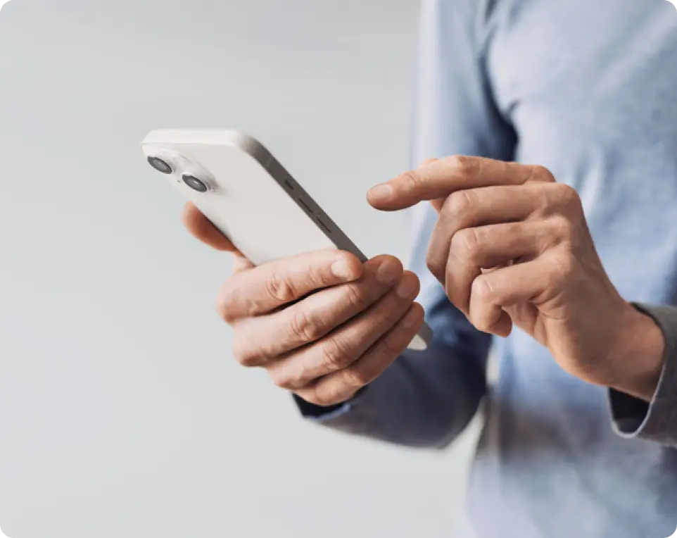 Person holding a phone in one hand and tapping screen with the other.