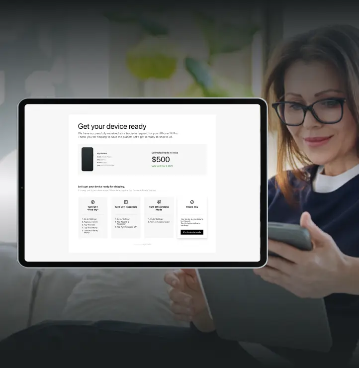 Woman with glasses holding a tablet showing a trade-in confirmation screen for an iPhone 14 Pro valued at $500 with steps to prepare the device for shipping.
