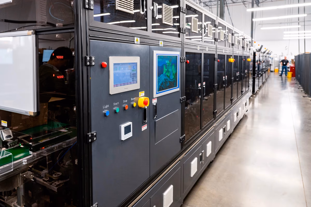 Row of automated device processing cells in a facility
