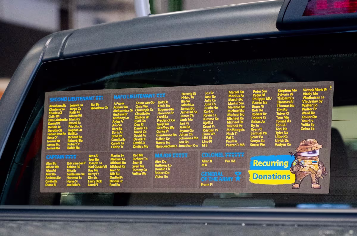  Black NAFO Truck covered in raindrops, displaying a large list of the names of the recurring donors names of ranks Second Lieutenant, NAFO Lieutenant Captain, Major and Colonel