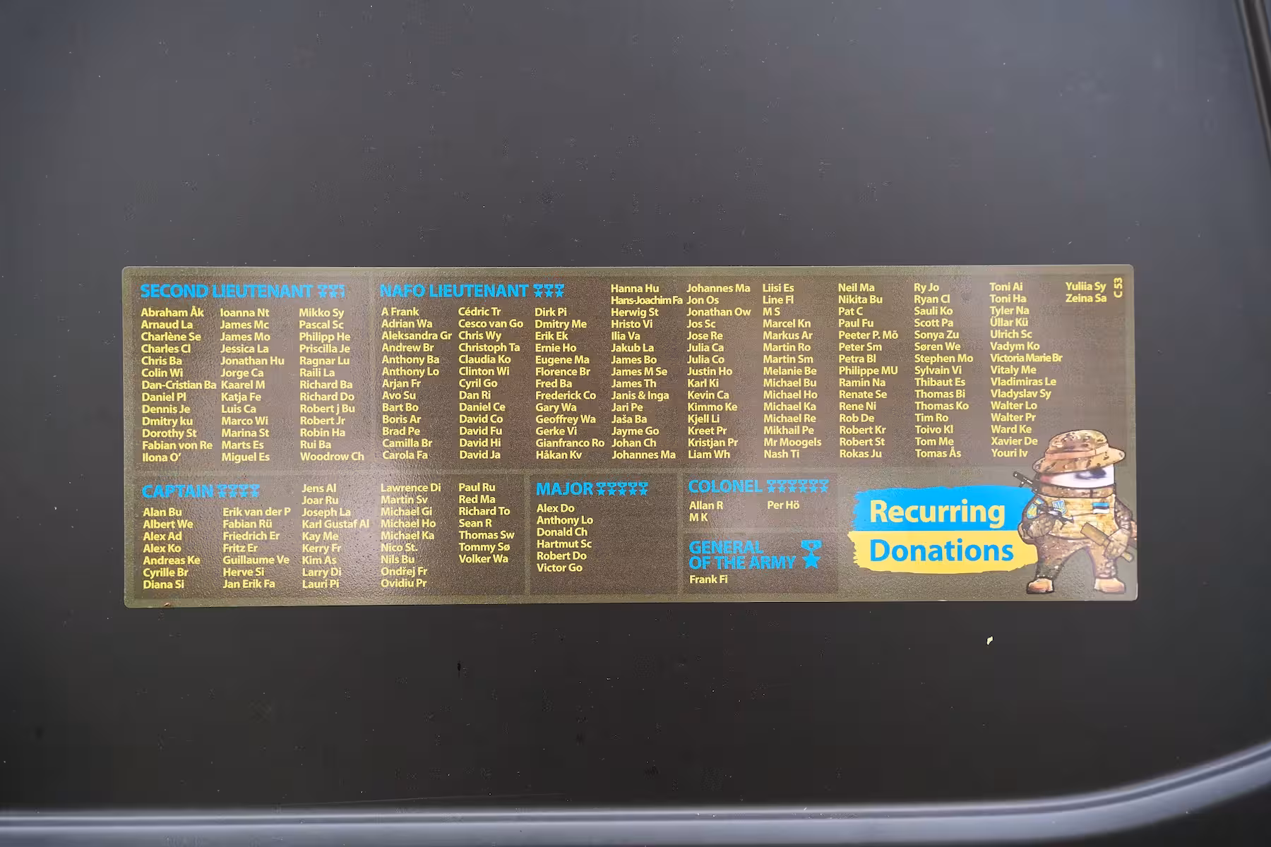 Black NAFO Truck, displaying a large list of the names of the recurring donors names of ranks of recurring donors of the 69th Sniffing Brigade Second Lieutenant, NAFO Lieutenant Captain, Major and Colonel