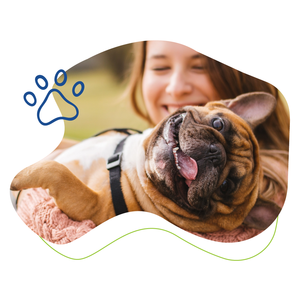 woman smiling and holding happy dog.