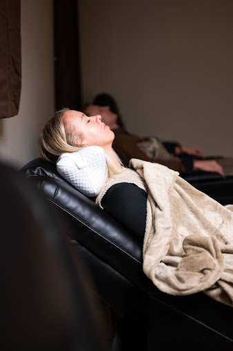 Ergonomic cervical pillow on a neatly made bed representing the connection between neck alignment and restorative sleep quality