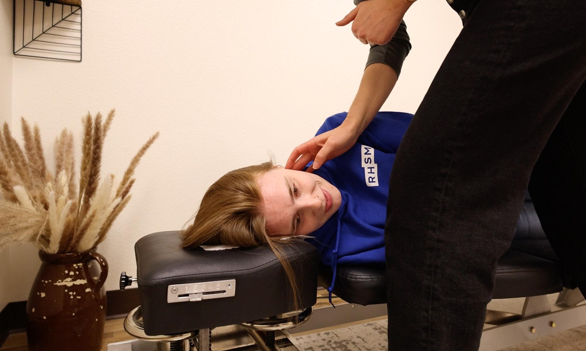 Chiropractor's hands gently positioned on a patient's upper neck representing the precise, non-invasive nature of upper cervical chiropractic adjustments
