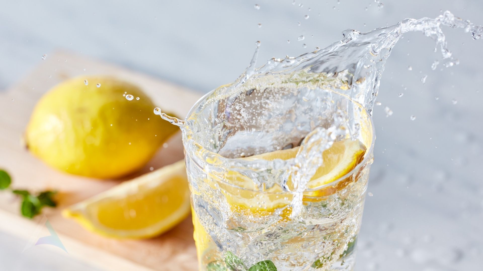 Tall glass of water with lemon representing the essential role of proper daily hydration in supporting nervous system health, CSF flow, and migraine prevention