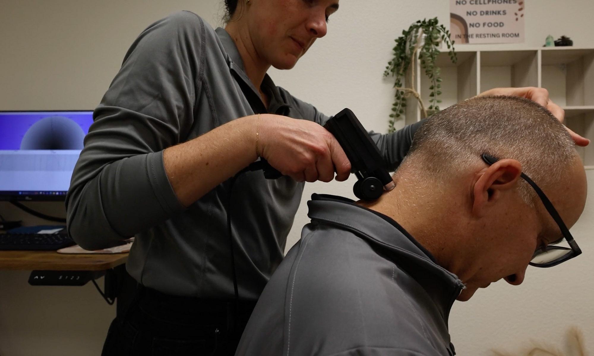 Modern upper cervical chiropractic clinic room with examination table and spine model representing the precise nervous system evaluation at Peak Upper Cervical Center