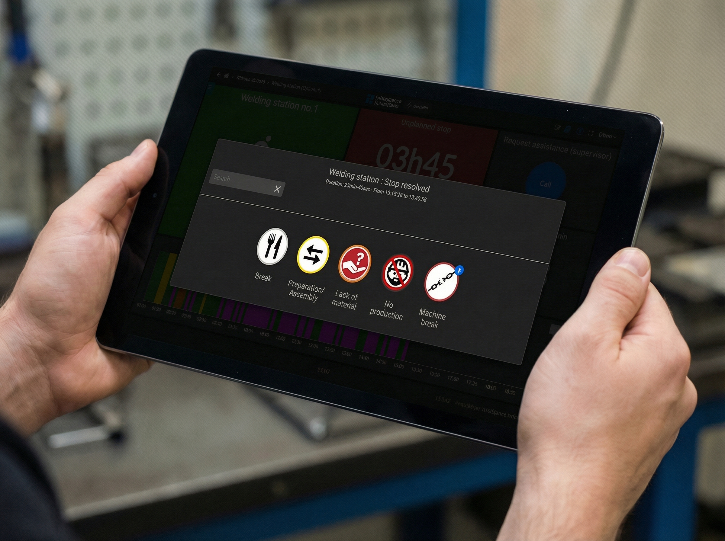 Operator holding a tablet on the shop floor showing the Intelligence Industrielle welding monitoring dashboard with real-time downtime reasons (break, setup, material shortage, machine breakdown).