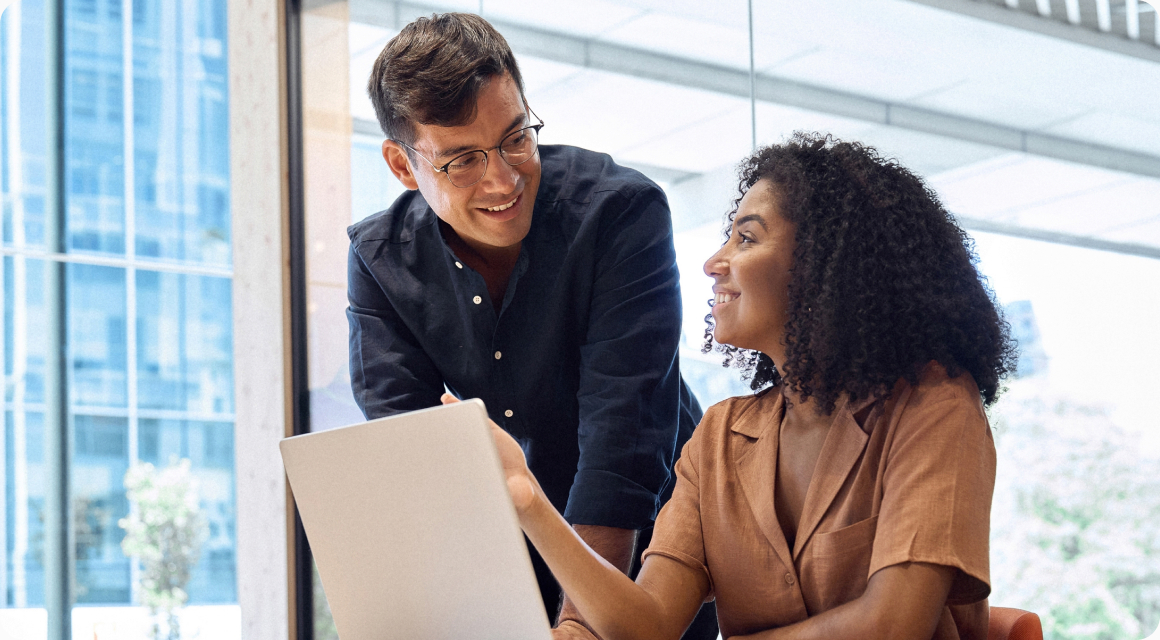 Two colleagues discussing work over a laptop