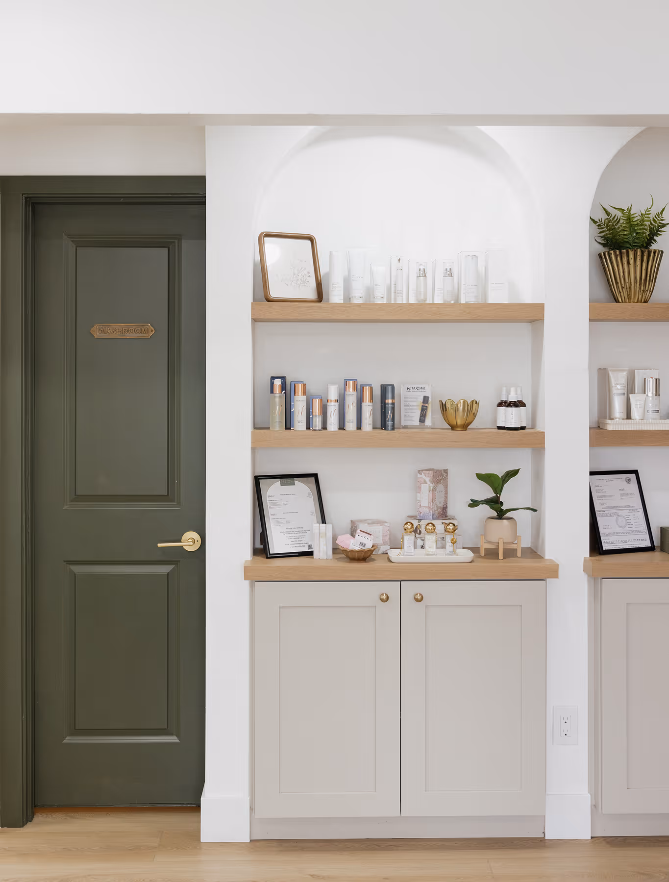 A room with a green door and some shelves.