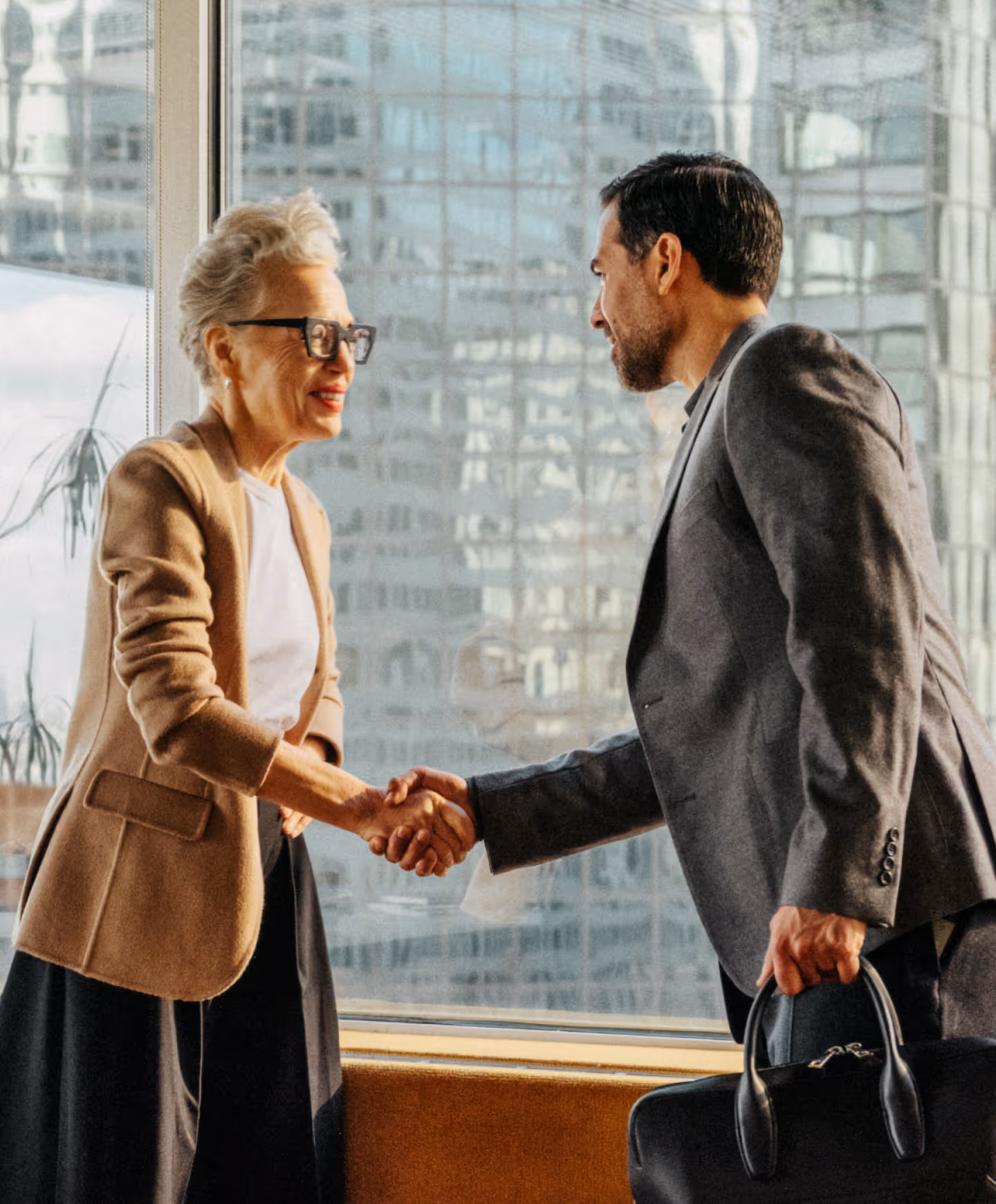 Image of coworkers shaking hands over desk