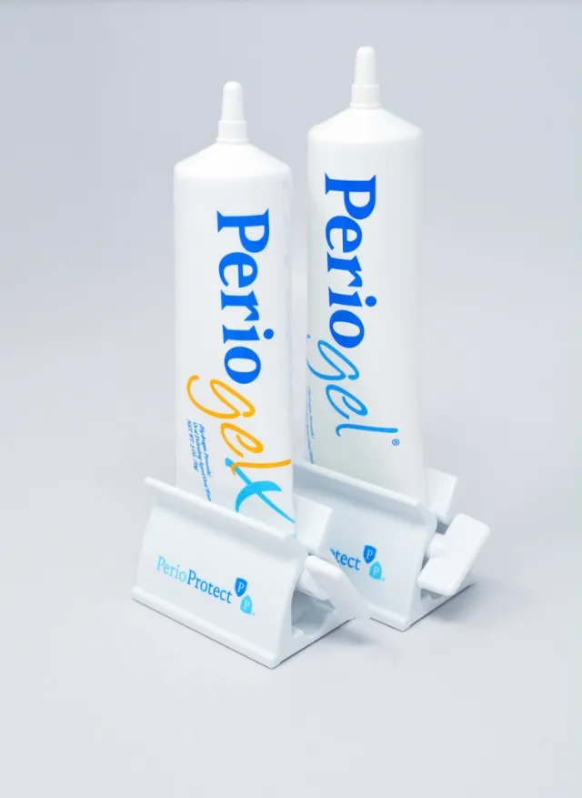 Two tubes of PerioGel® and PerioGel® X prescription gel standing in white PerioProtect® tube squeezers against a plain light background.