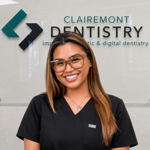 Clairemont Dentistry team member with long highlighted brown hair wearing glasses and black scrubs