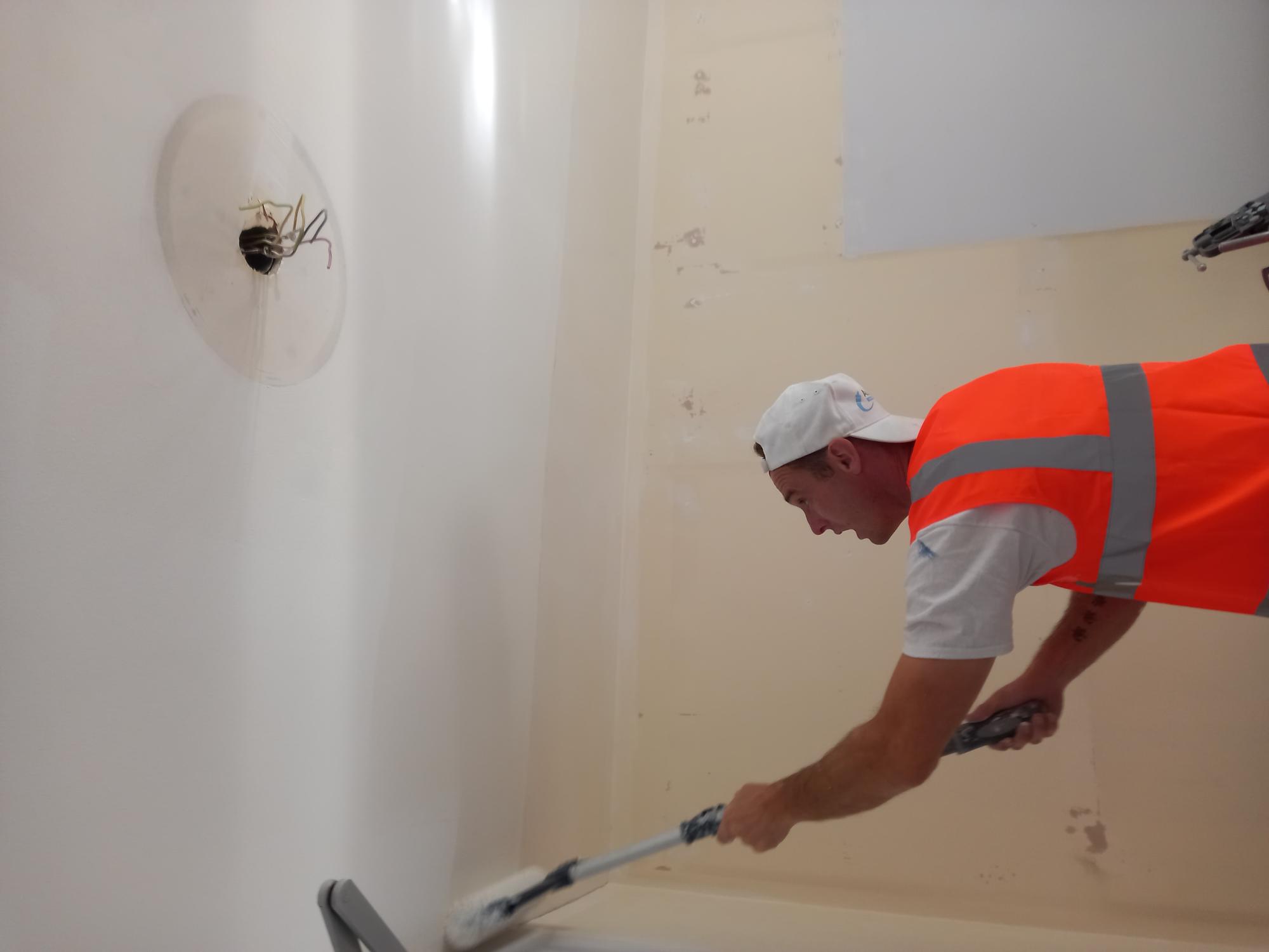 Employee at Allpoints Painters and Decorators painting a ceiling.