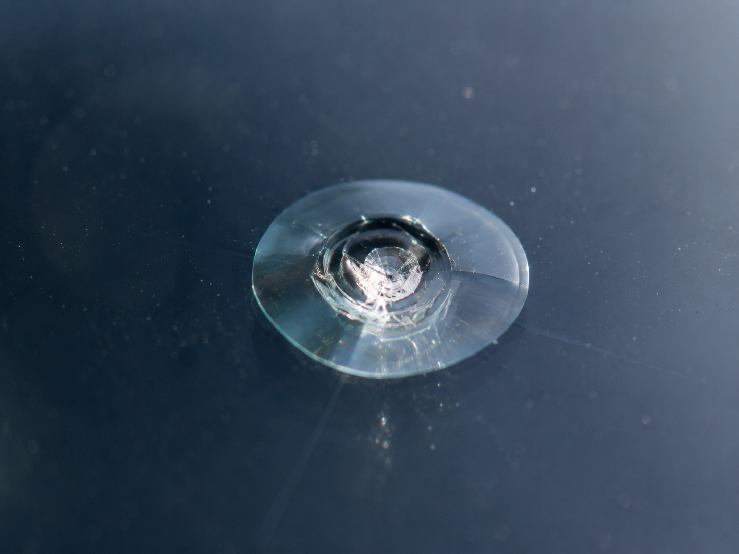 Bullseye windshield chip with circular impact damage in the glass