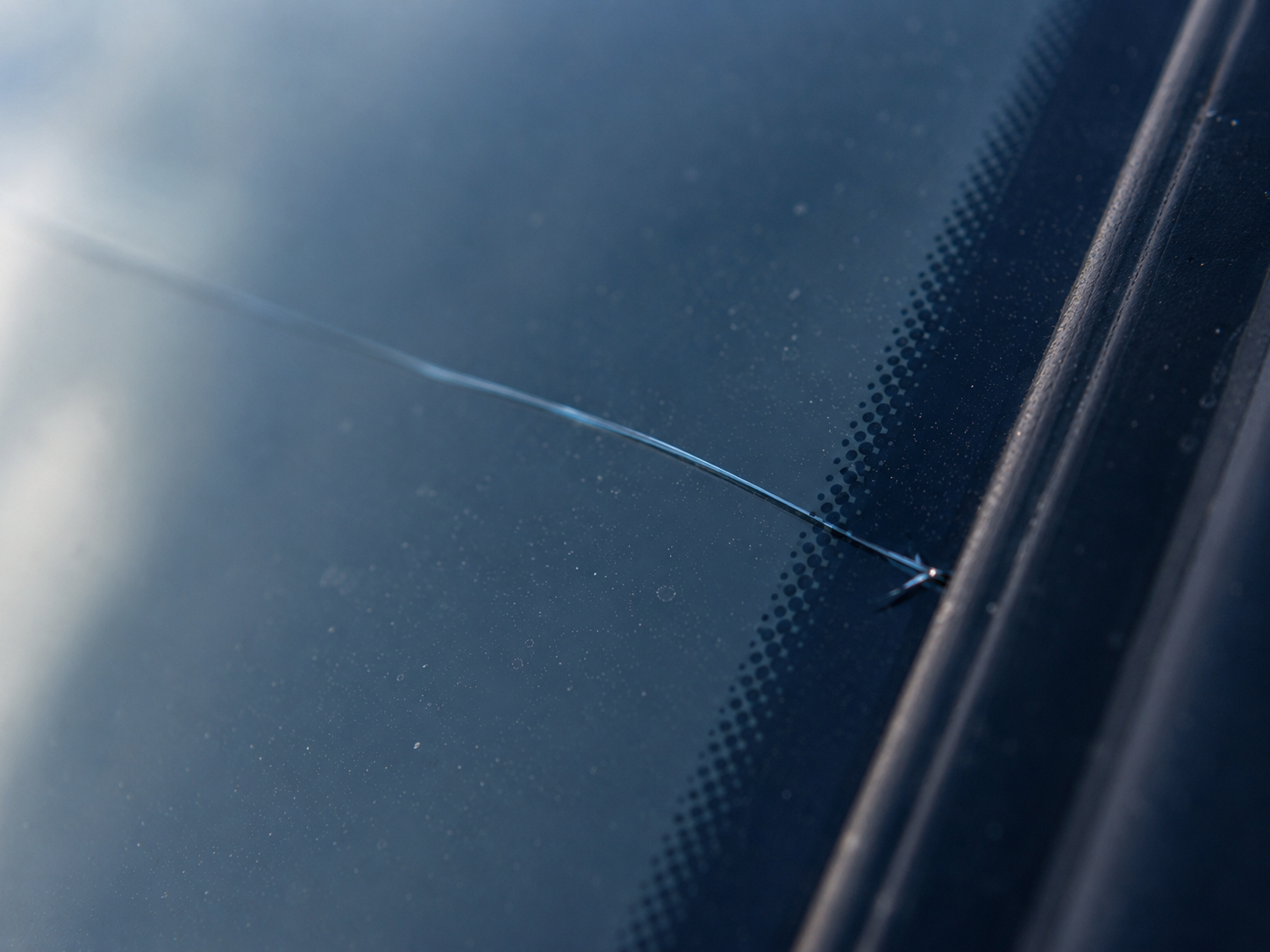 Windshield edge crack starting near the black glass border and spreading inward