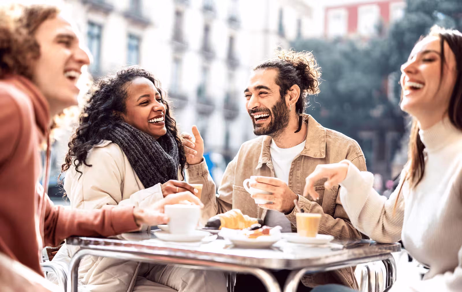 A group of people sitting at a table with food and drinks.