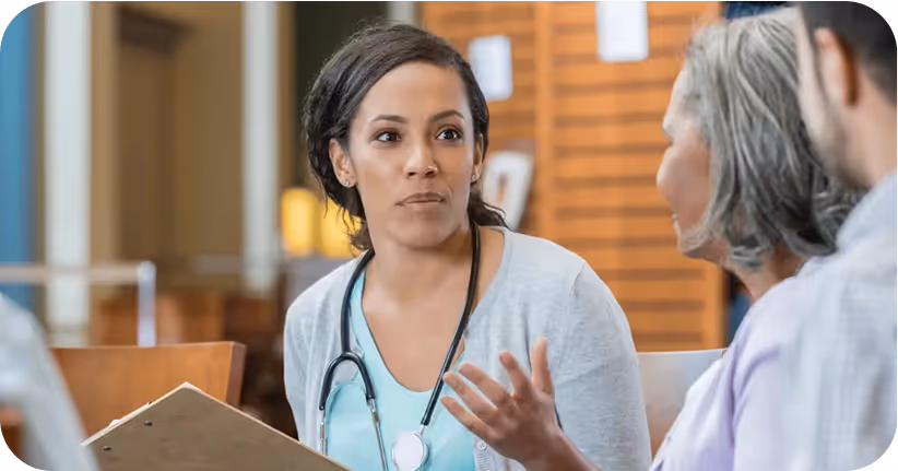 A woman wearing a white shirt and a stethoscope talking to another person.