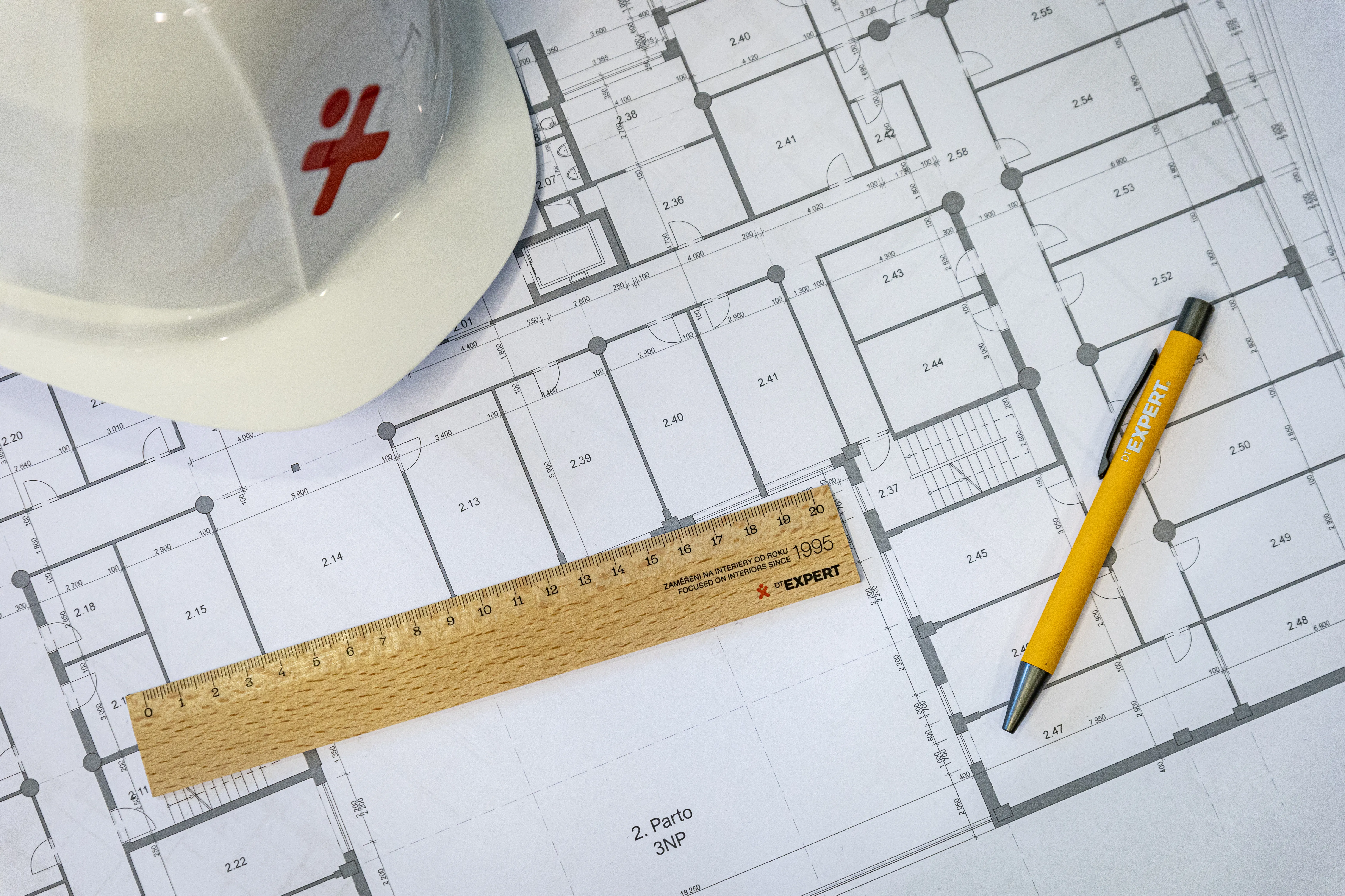 Hard hat, plans, ruller and a pen on a table