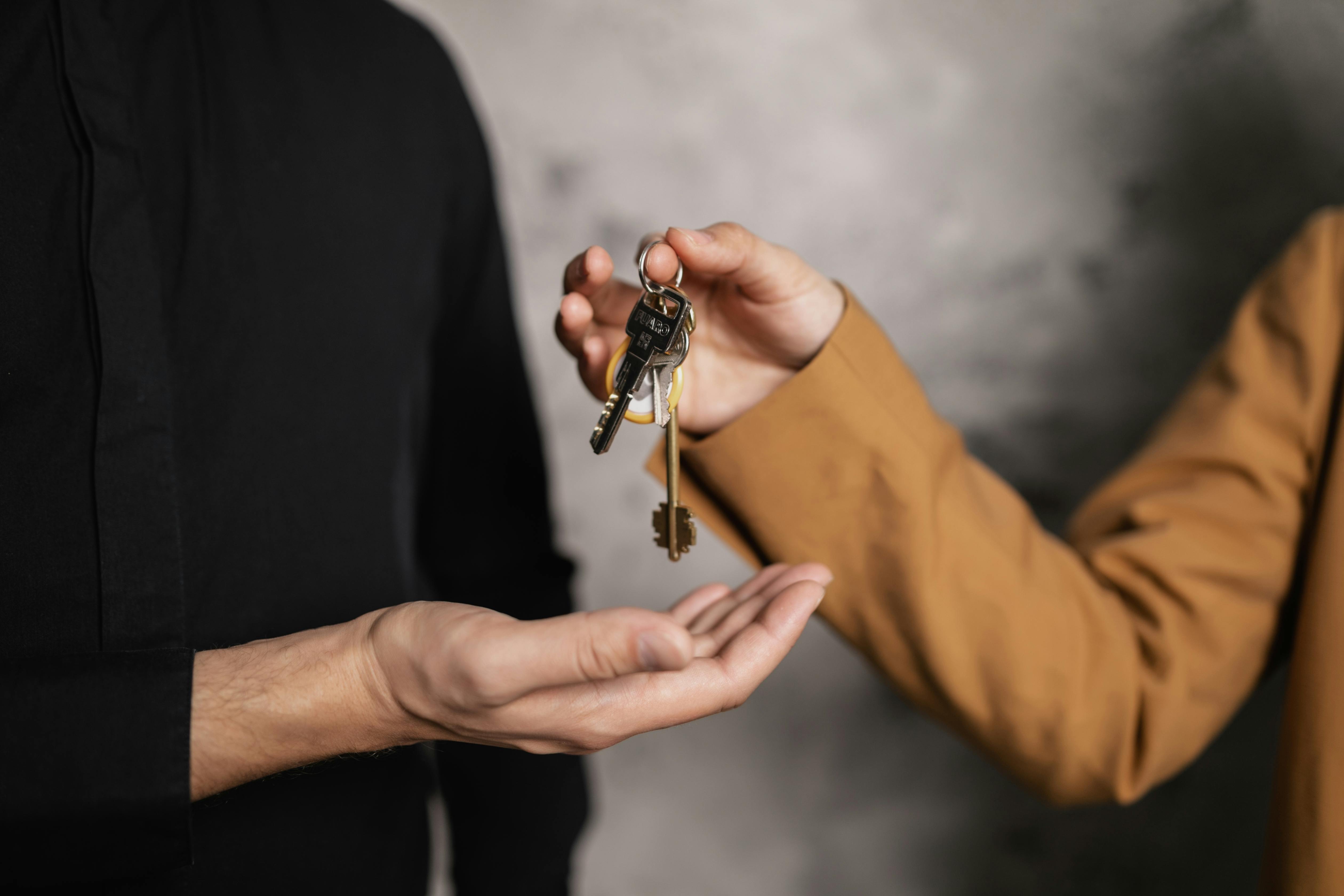 Two people handing over keys