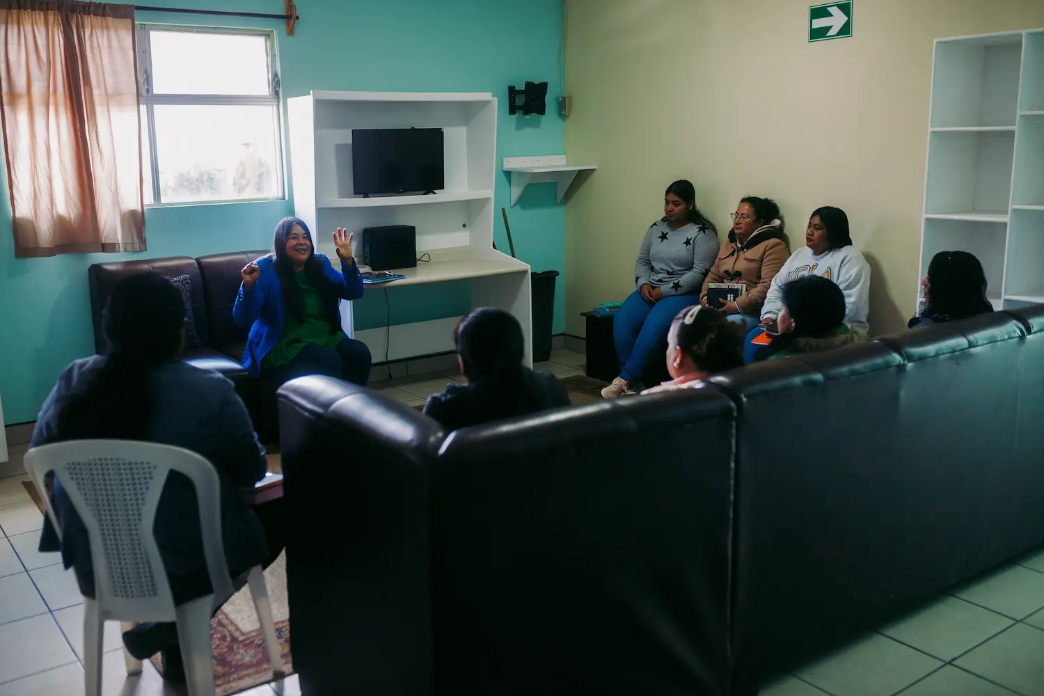 Tia Vicky leading a staff meeting with the residential care team at Oasis