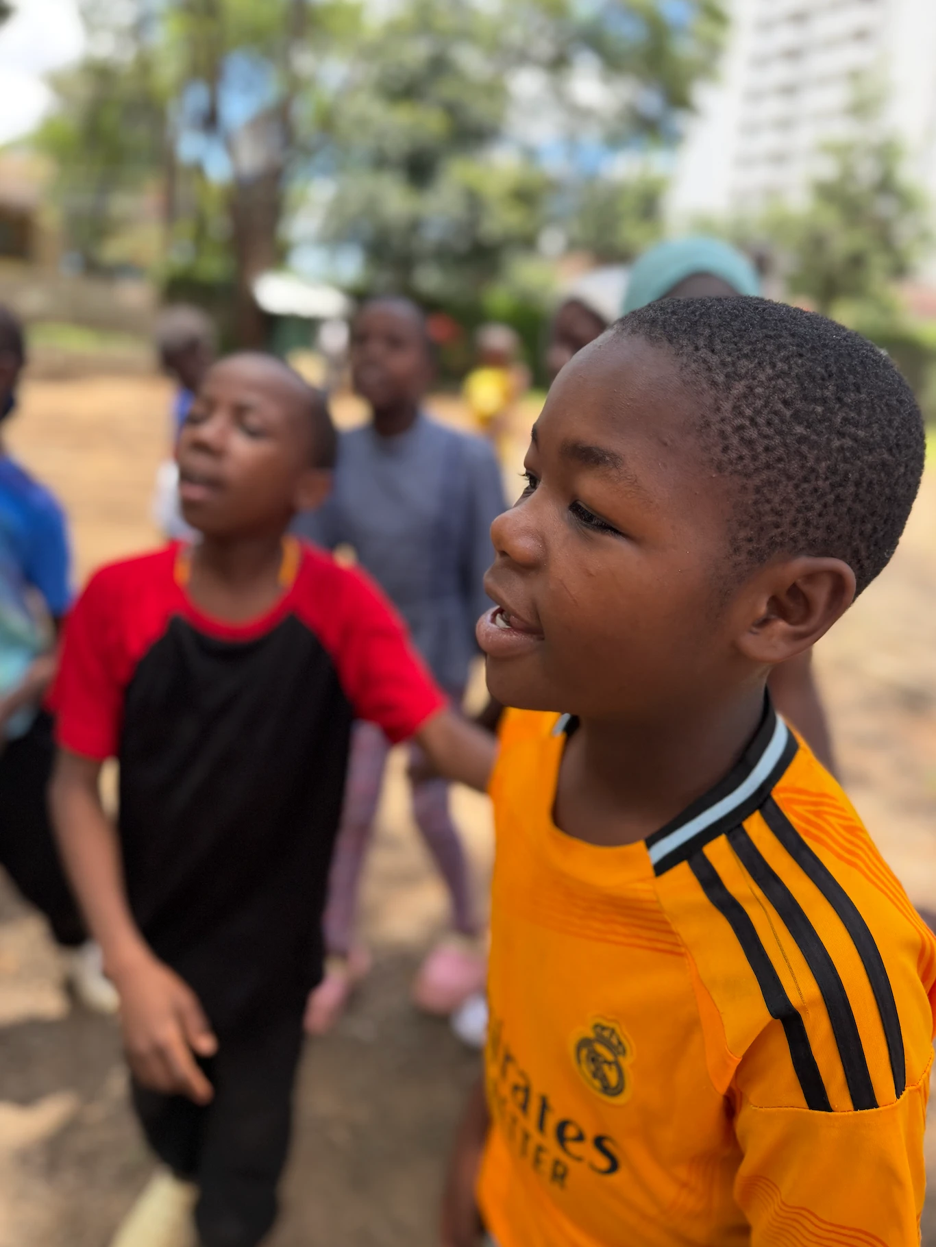 Ayaan smiling as he plays with children at the Nairobi Hope Center.