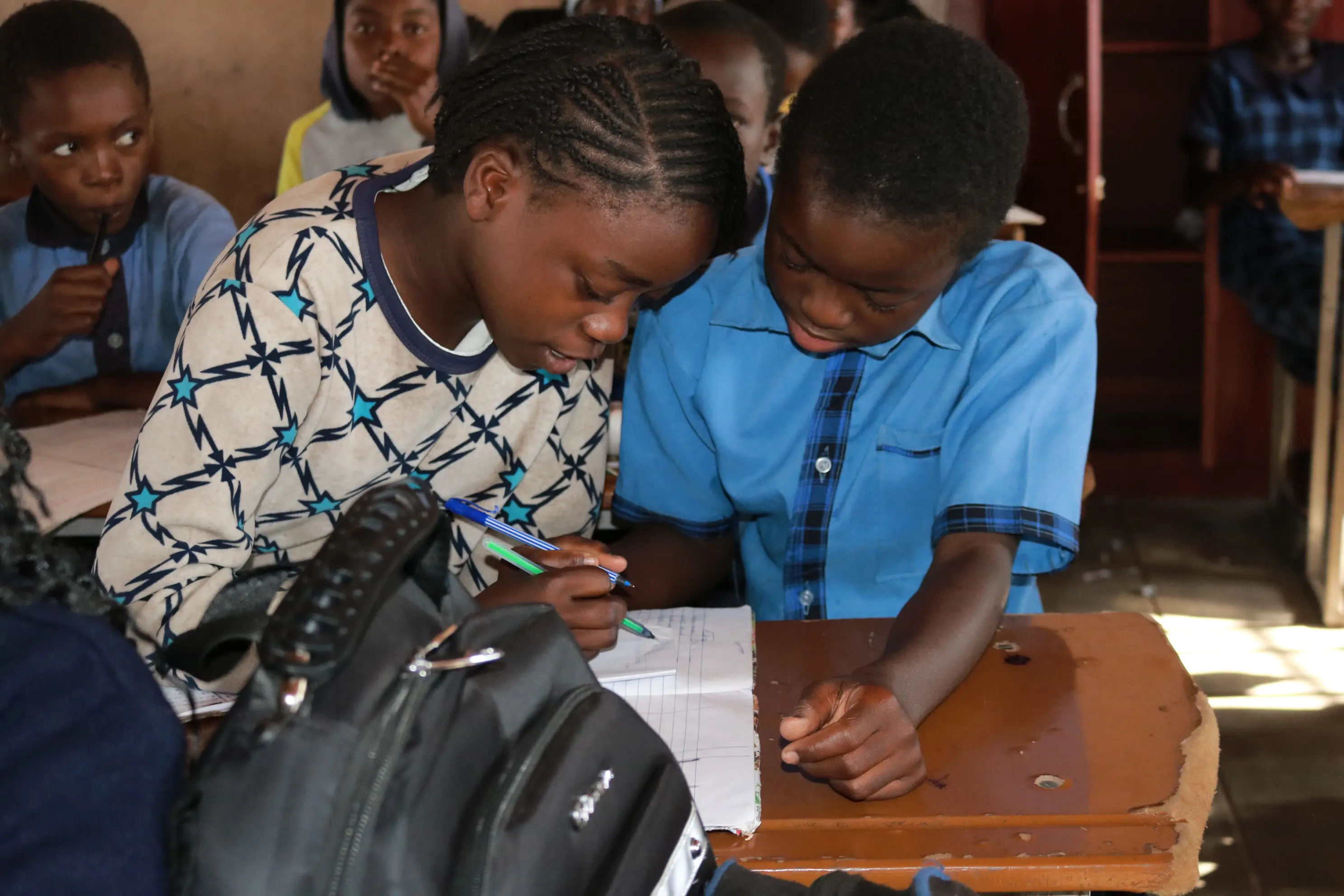Zangi helps her classmate at Kids Alive Academy Zambia.