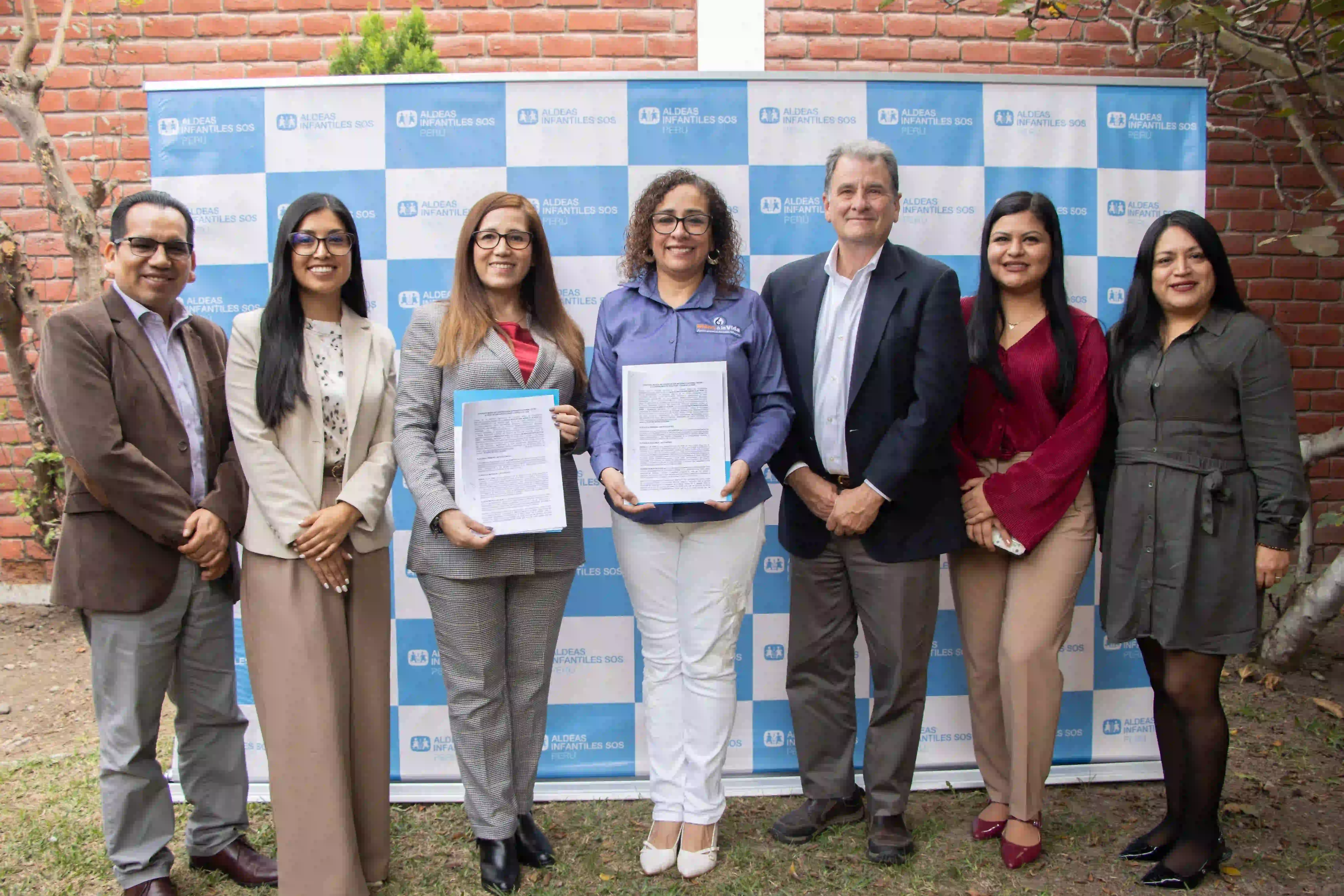 Kids Alive Peru leadership signing partnership agreements for justice advocacy.