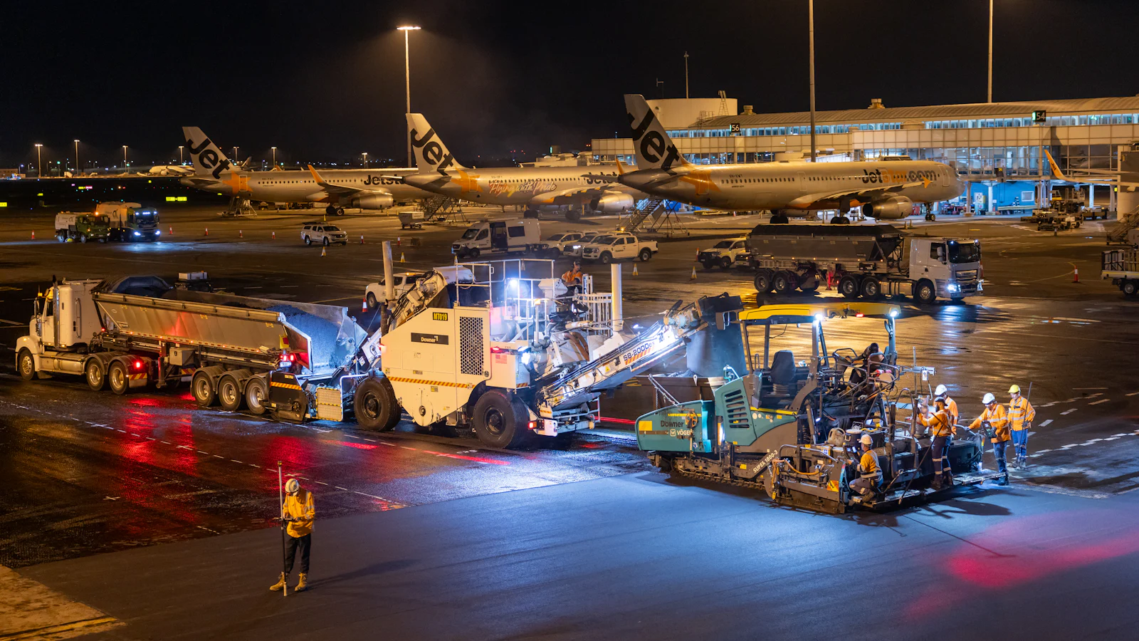 Véhicules de piste et camions de carburant sur le tarmac de nuit