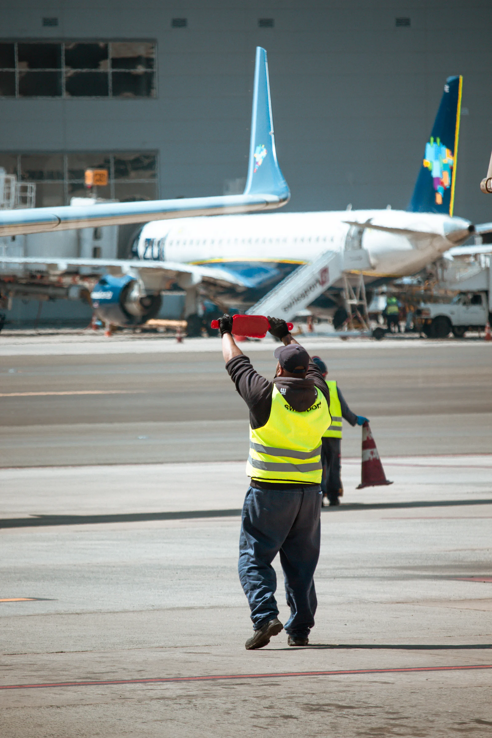 Agent de piste en gilet haute visibilité sur le tarmac