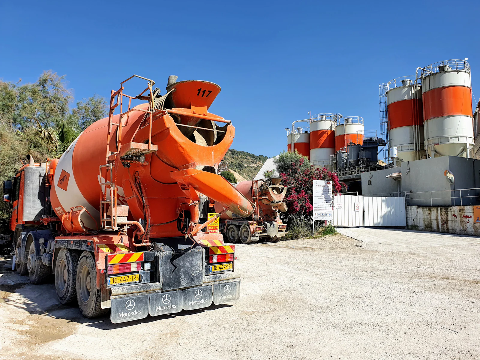 Camion toupie devant les silos d'une centrale à béton