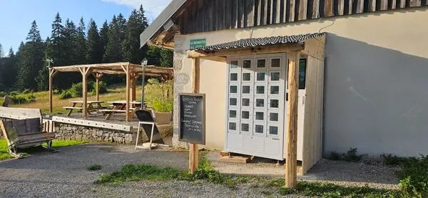 Le distributeur de produits du terroir de l'Auberge La Grangette est installé près de la terrasse et est protégé par un abri minimaliste.