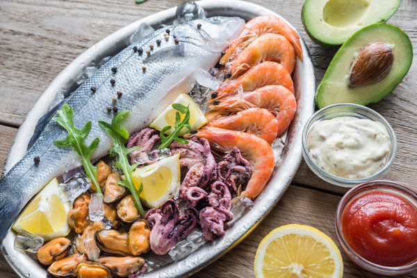 Photographie de différents fruits de mer vendus dans les casiers réfrigérés en plus des huîtres spéciales : crevettes, moules, noix de Saint-Jacques.