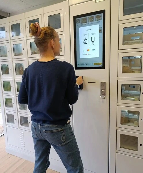 Une cliente commande son produit en totale autonomie dans un magasin automatique