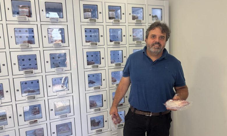 Stéphane Miaille pose devant ses casiers réfrigérés.
