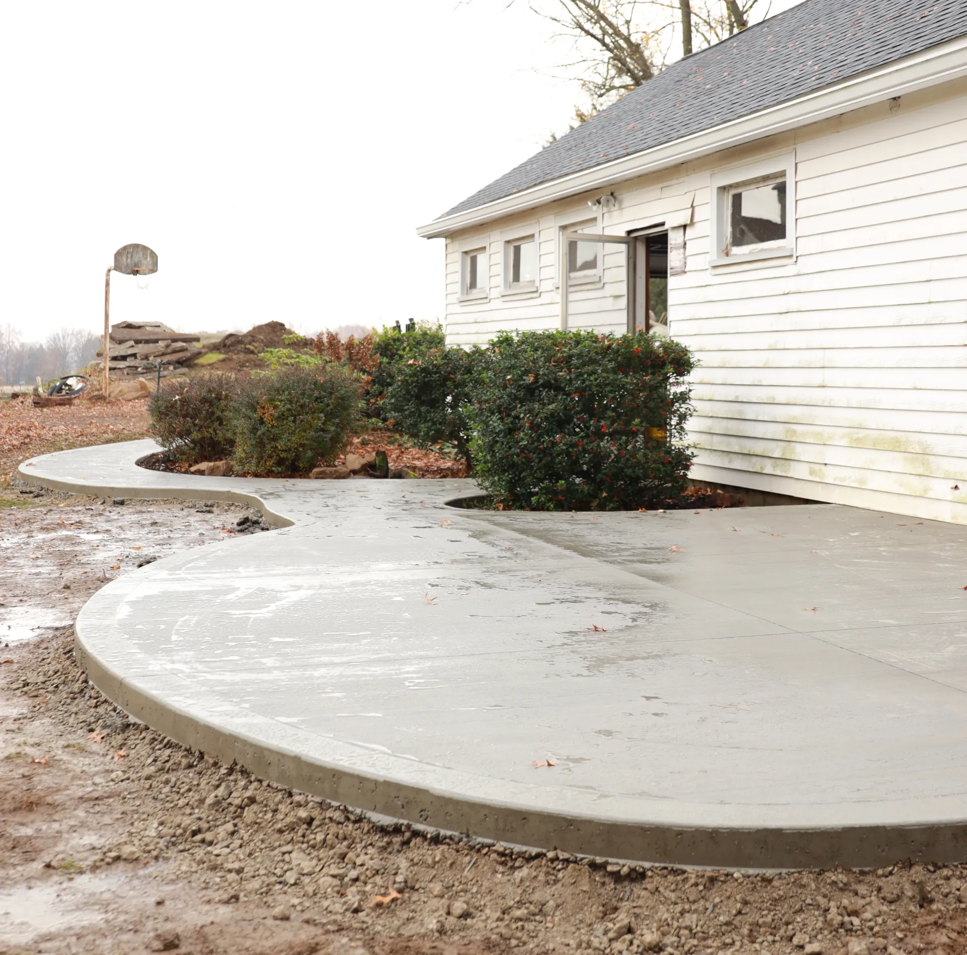 new concrete patio in backyard of white house