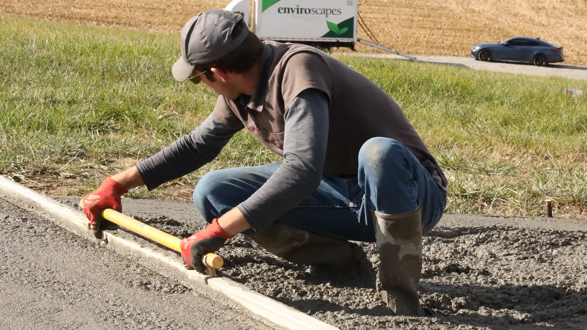 Concrete worker leveling out concrete with a leveling tool