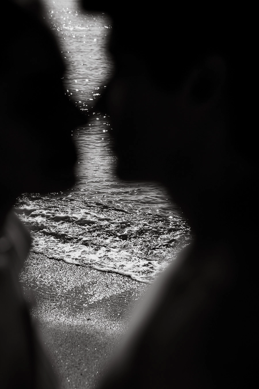 Silhouette d’un couple sur le point de s’embrasser, avec la mer en arrière-plan, photographie en noir et blanc réalisée pour la campagne Sweet Disruption de D’Orsay Paris par Laetizia Debain.