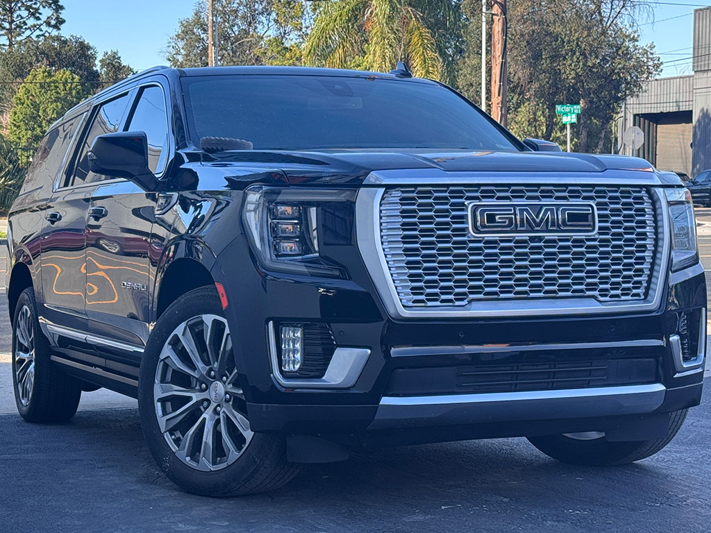 Restored black GMC Yukon Denali after factory-certified collision repair featuring perfect body lines, OEM LED headlight installation, and high-gloss black paint finish.