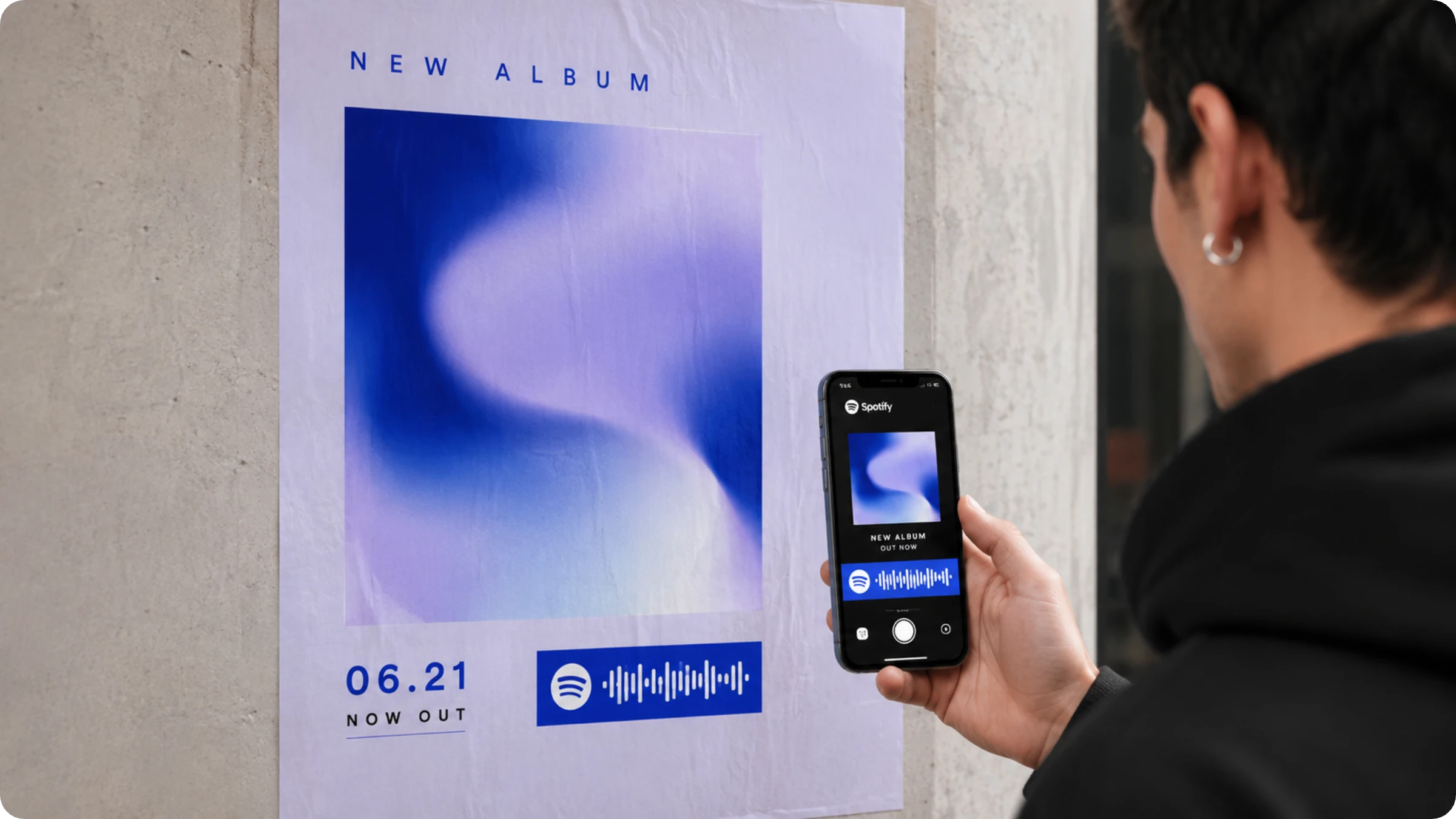 man scanning a Spotify QR Code on a poster