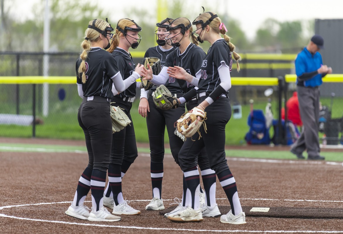 A youth club softball team gathers in the pitcher's circle before starting a game at Sandhills Global Youth Complex.