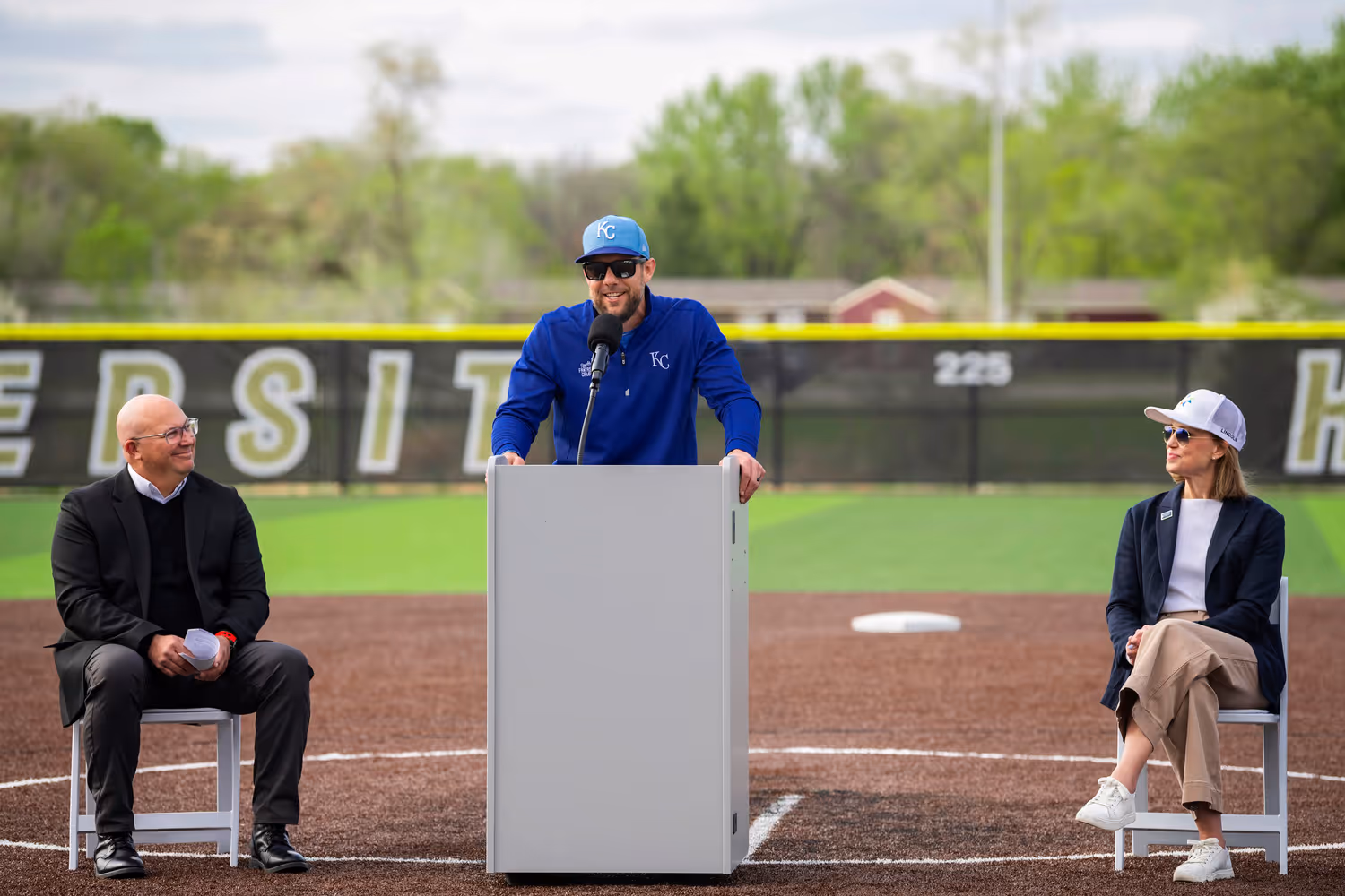 Charlie Colon, nonprofit board president of the Sandhills Global Youth Complex, and Lincoln Mayor Leirion Gaylor Baird listen as former Major League Baseball All Star Alex Gordon addresses the grand opening ceremony at the complex.