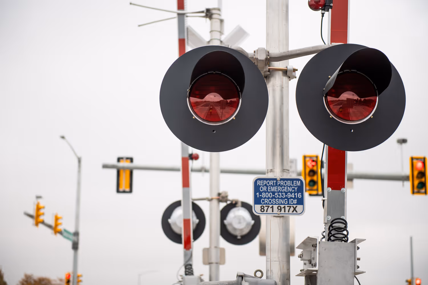 Blue-and-white notification signs provide an emergency number to call if a vehicle stalls on the tracks. 