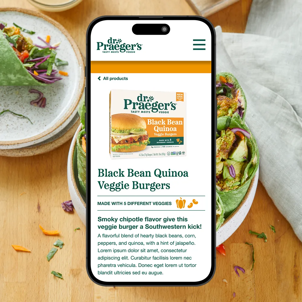 Smartphone displaying Dr. Praeger's Black Bean Quinoa Veggie Burgers product page with veggie wrap in background.
