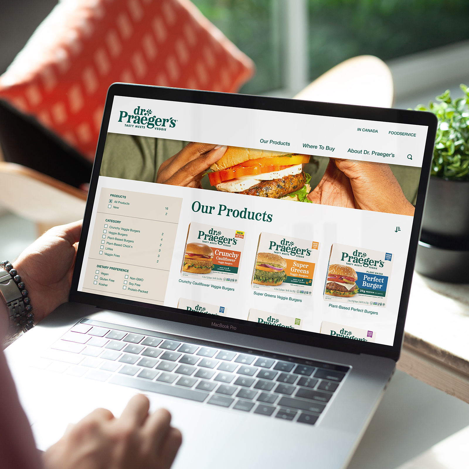 Person browsing Dr. Praeger's website products page featuring veggie burger options on a MacBook Pro laptop.
