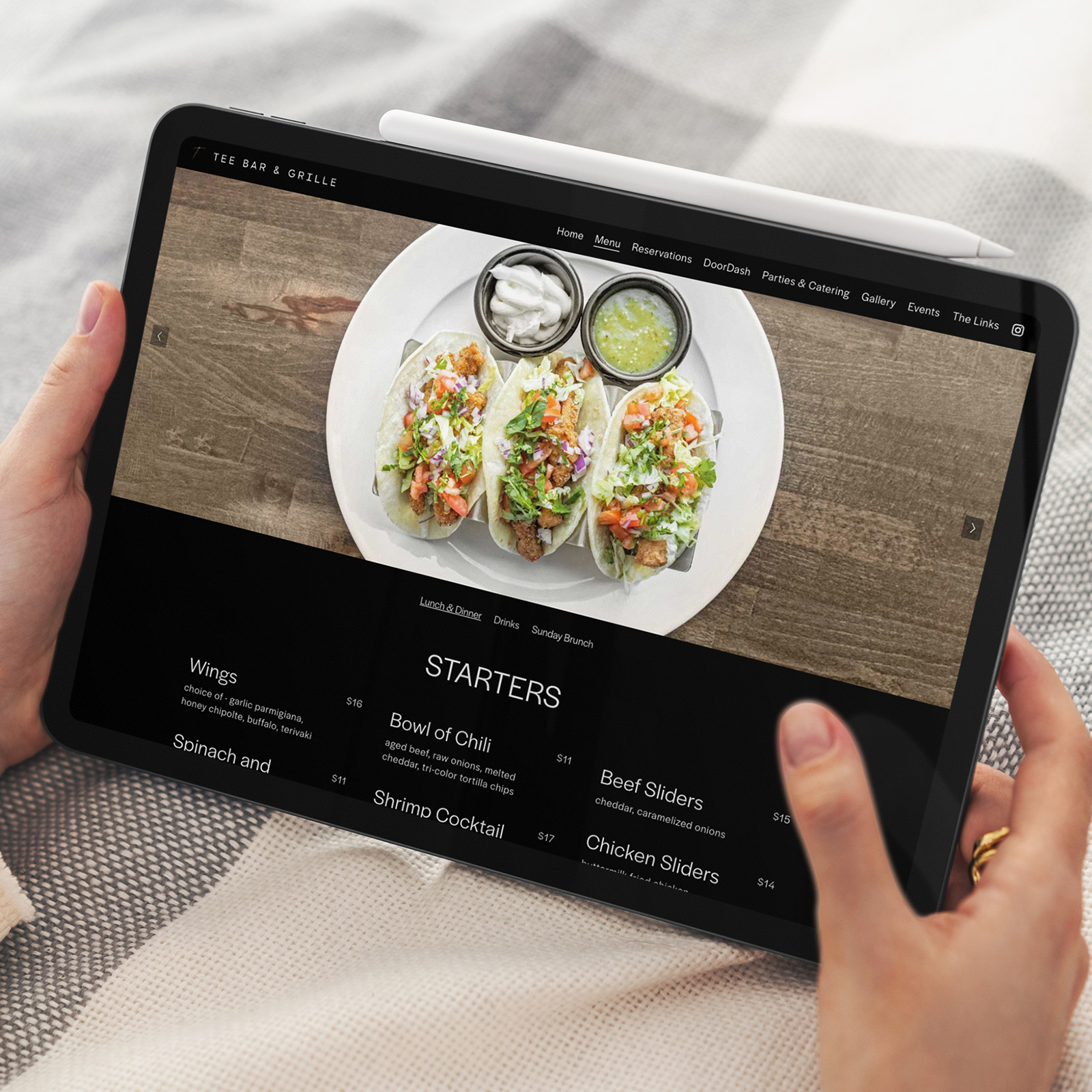 Tablet screen showing a restaurant menu with three tacos topped with lettuce, tomato, and sauces, under the Starters section.